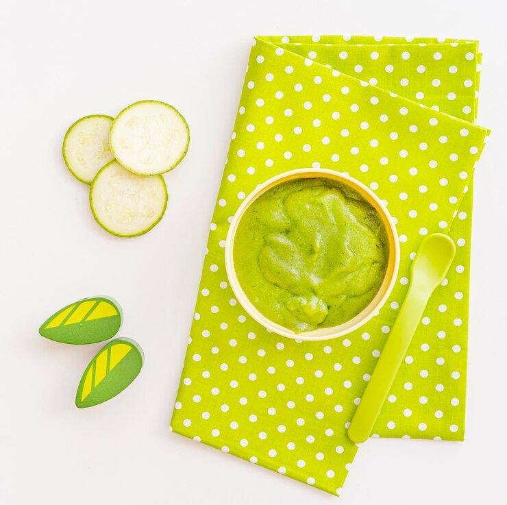 Foto grátis tigela com purê de pepino para o bebê na mesa