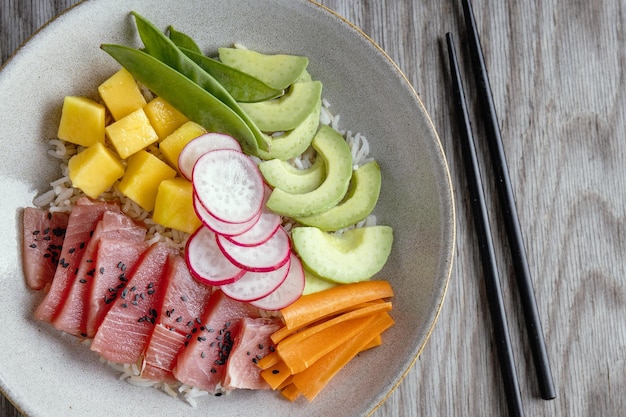 Tigela de atum cru saudável com legumes servidos no prato Closeup
