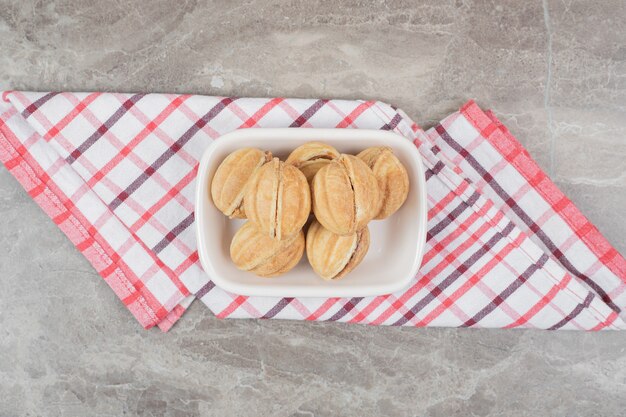 Tigela de biscoitos em forma de noz na toalha de mesa.