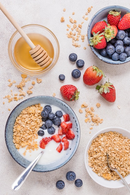 Foto grátis tigela de café da manhã vista superior com mel e frutas