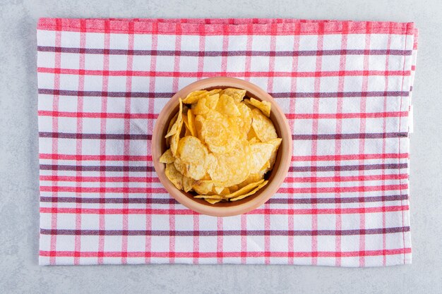 Tigela de cerâmica com deliciosas batatas fritas crocantes no fundo de pedra.