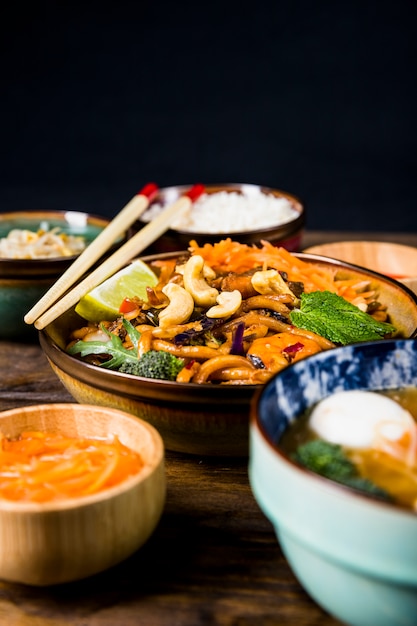 Tigela de macarrão udon tailandês com nozes; brócolis; coberturas de limão e hortelã