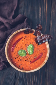 Tigela de sopa cremosa de pimenta vermelha grelhada