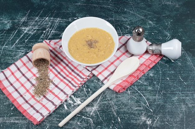 Tigela de sopa de lentilha, sal, especiarias e toalha de mesa em fundo de mármore. foto de alta qualidade