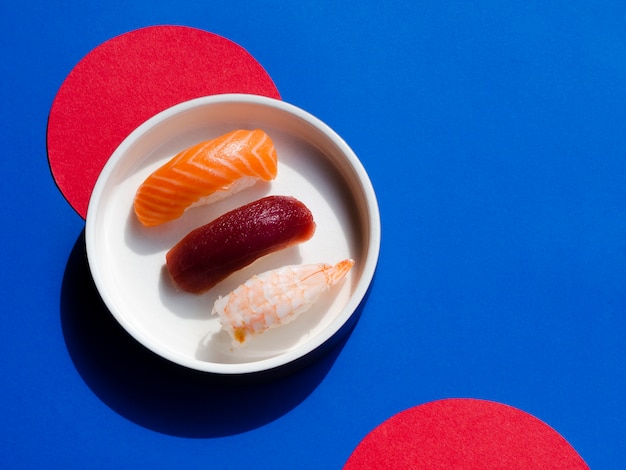 Foto grátis tigela de sushi em um fundo vermelho e azul