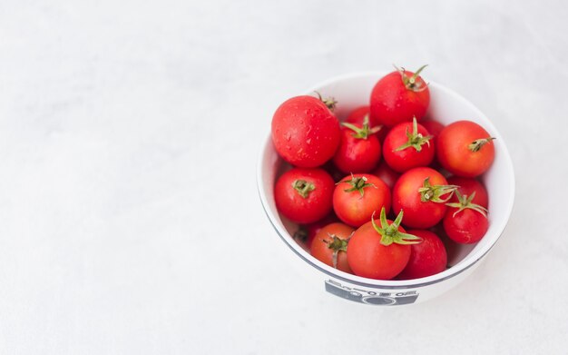 Tigela de tomates vermelhos no fundo branco