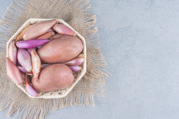 Tigela de vegetais frescos orgânicos. Batatas e cebolas vermelhas