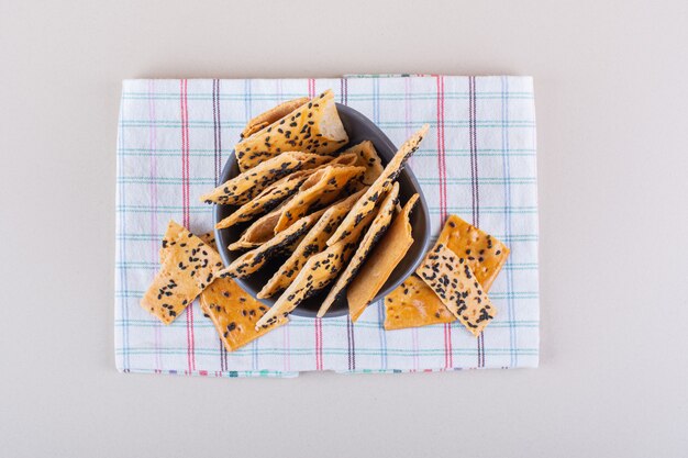 Tigela funda de biscoitos com sementes pretas sobre fundo branco. Foto de alta qualidade