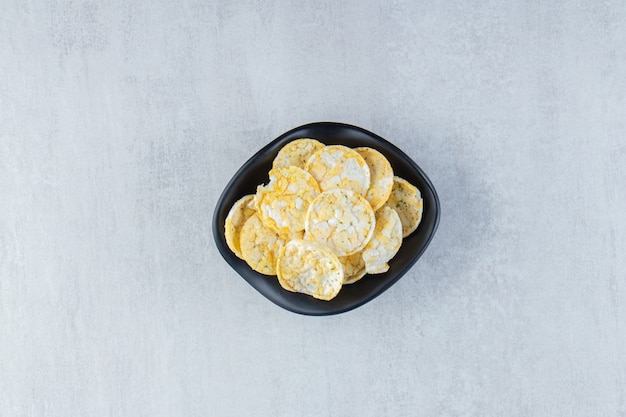 Foto grátis tigela preta de deliciosas batatas fritas de arroz na pedra.