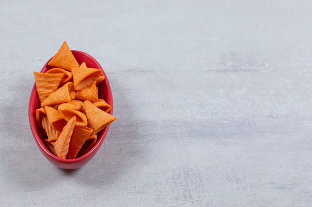 Tigela vermelha cheia de batatas fritas picantes.