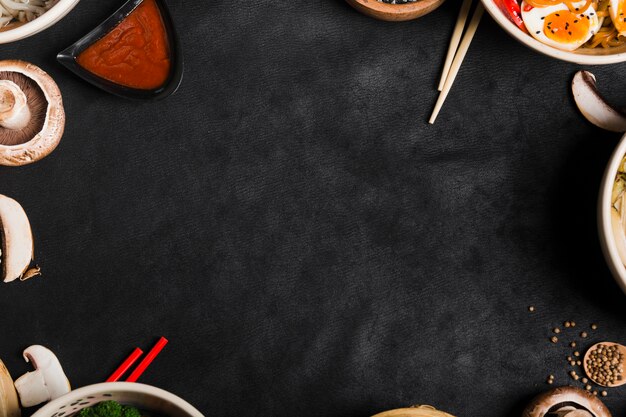 Tigelas de comida de estilo asiático com pauzinhos e copie o espaço para escrever o texto