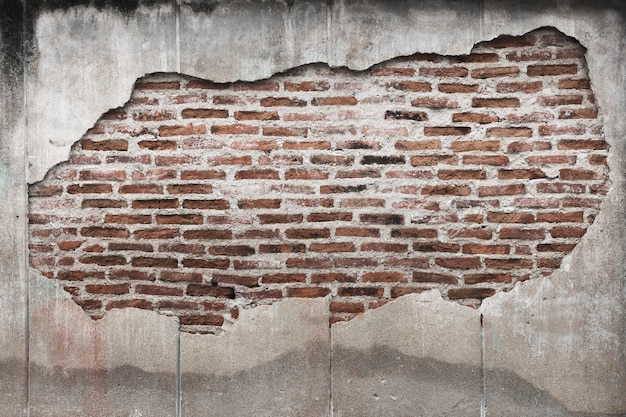 Tijolos de grunge em uma parede de concreto rachada com plano de fundo texturizado