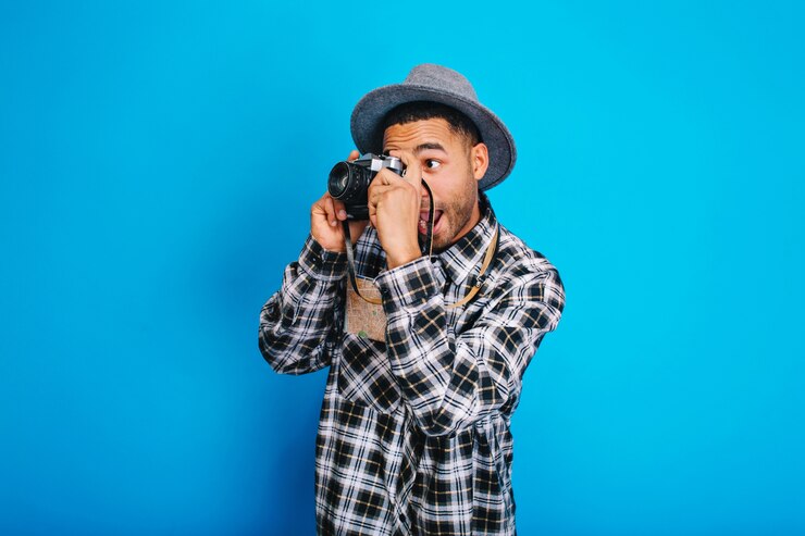 Foto grátis tipo de turista animado engraçado retrato no chapéu fazendo foto na câmera. divertir-se, curtir férias, fins de semana, viajar pelo mundo, expressar positividade.