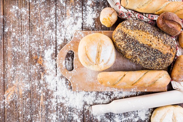 Tipo diferente de pães assados ​​com farinha na mesa de madeira