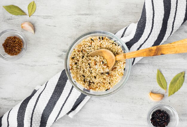 Tipos diferentes de arroz em taças com colher na mesa de luz