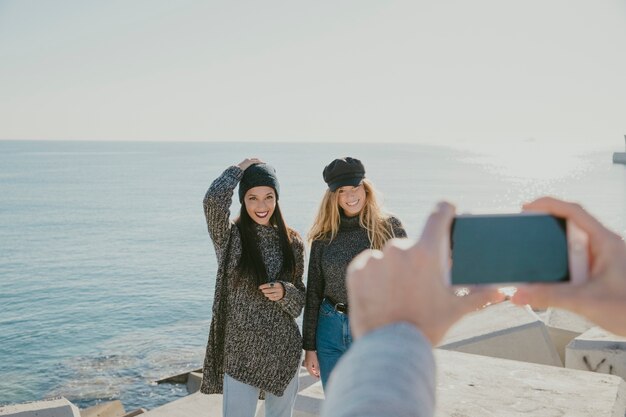 Tirar foto com smartphone de meninas em frente ao mar