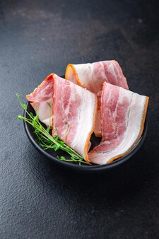 Tiras de bacon fatia fina fatiar gordura de porco refeição saudável dieta lanche na mesa copiar espaço