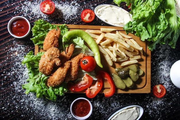 Tiras de frango frito com batatas, ervas e picles