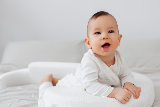 Foto grátis tiro completo bebê fofo deitado na cama