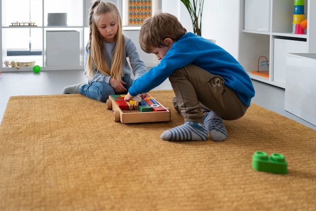 Foto grátis tiro completo crianças brincando com brinquedos de madeira