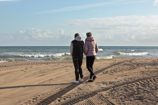 Tiro completo de pessoas andando na praia