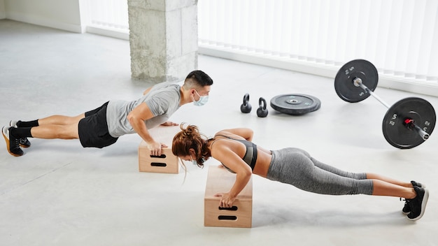 Foto grátis tiro completo, homem e mulher fazendo flexões