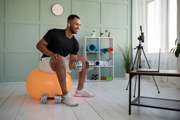 Tiro completo homem fazendo exercícios com bola de ginástica