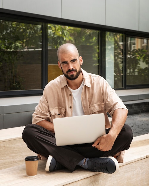 Tiro completo homem segurando laptop