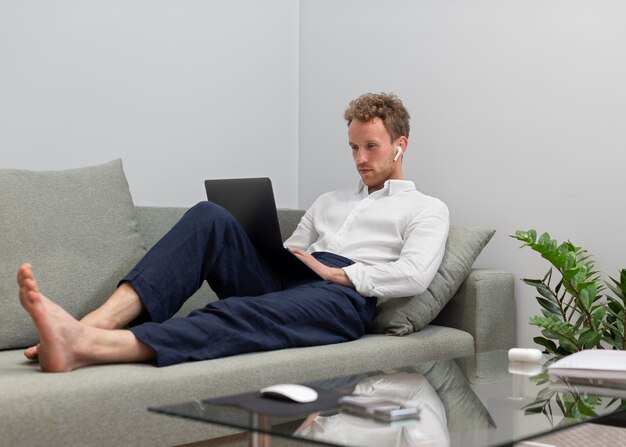 Tiro completo homem trabalhando em um laptop