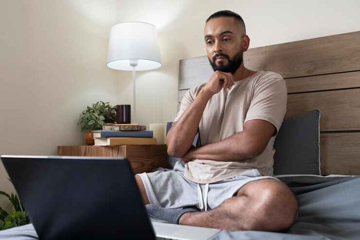 Foto grátis tiro completo homem trabalhando na cama