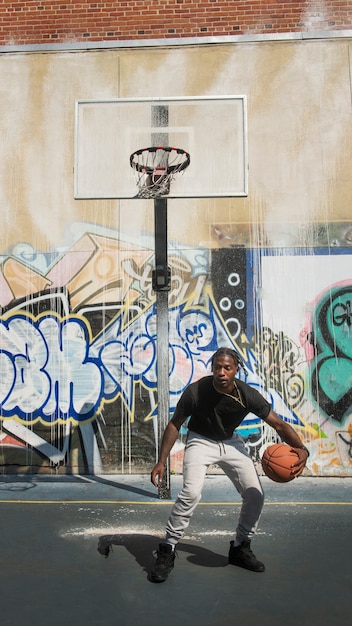 Foto grátis tiro completo jovem jogando basquete