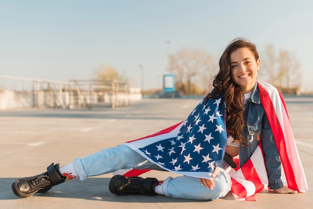 Foto grátis tiro completo jovem mulher com grande bandeira dos eua