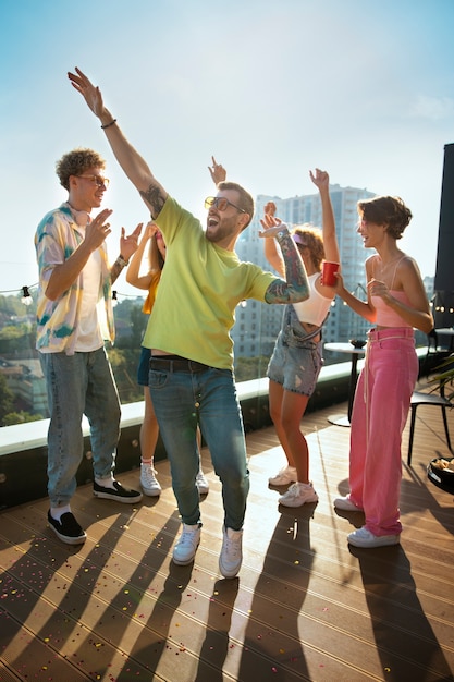 Foto grátis tiro completo jovens felizes festejando ao ar livre