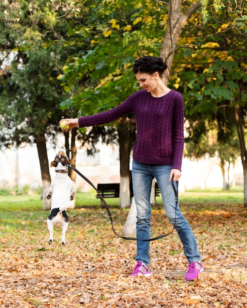 Tiro completo mulher brincando com seu cachorro