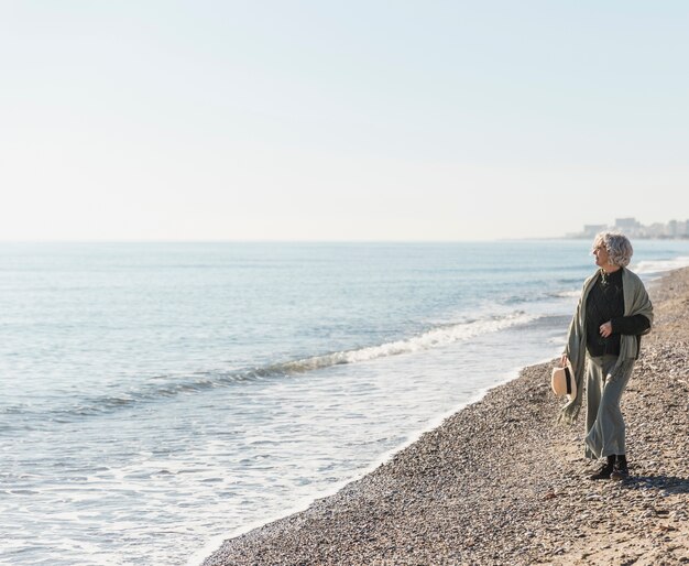 Foto grátis tiro completo mulher caminhando na praia