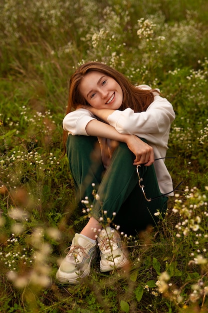 Foto grátis tiro completo mulher sorridente posando ao ar livre