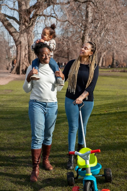 Foto grátis tiro completo mulheres felizes e criança no parque