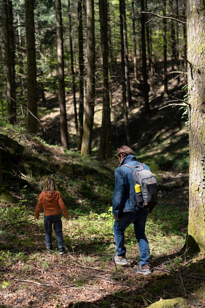 Tiro completo pai e filha na floresta