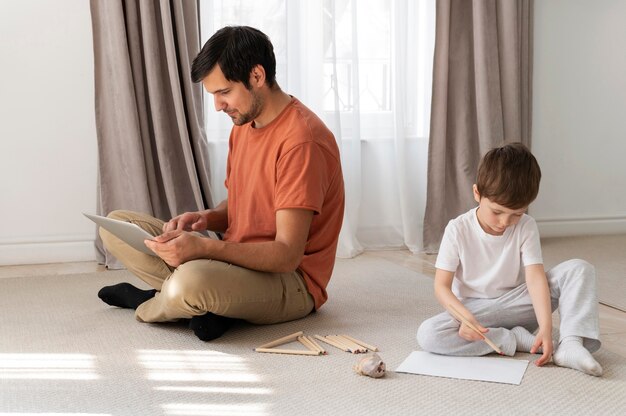 Tiro completo pai e filho no chão