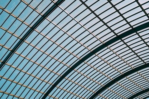 Tiro de ângulo baixo de um telhado de vidro de um edifício moderno sob o céu azul