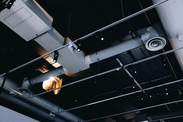 Tiro de ângulo baixo de um teto de metal preto com tubos de ventilação brancos