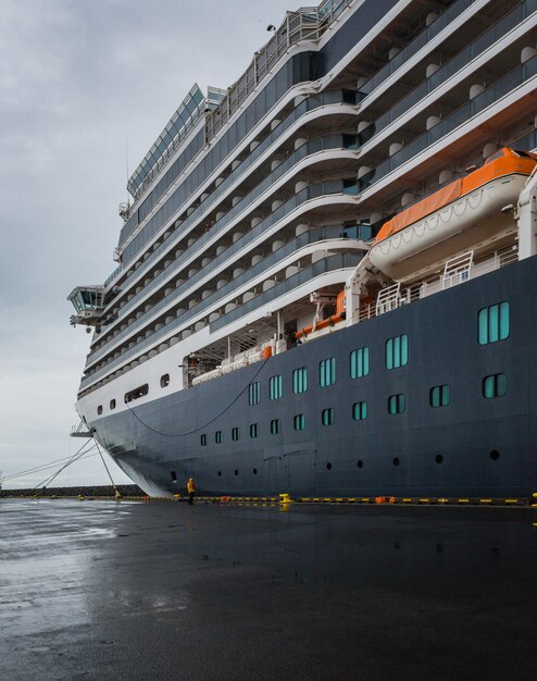 Tiro de ângulo baixo vertical de um enorme navio de cruzeiro ancorado na Islândia sob o céu claro