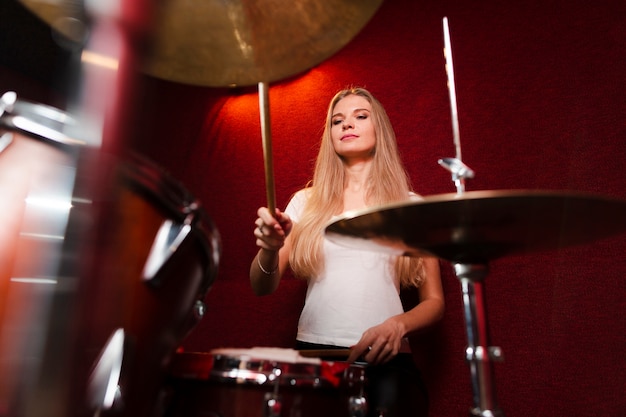 Tiro de baixa vista da menina tocando os pratos