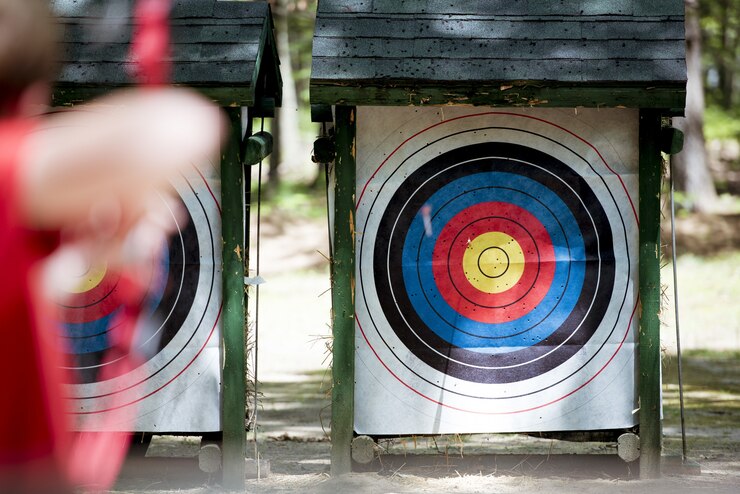 Foto grátis tiro de foco seletivo de um alvo com uma pessoa borrada usando arco e flecha