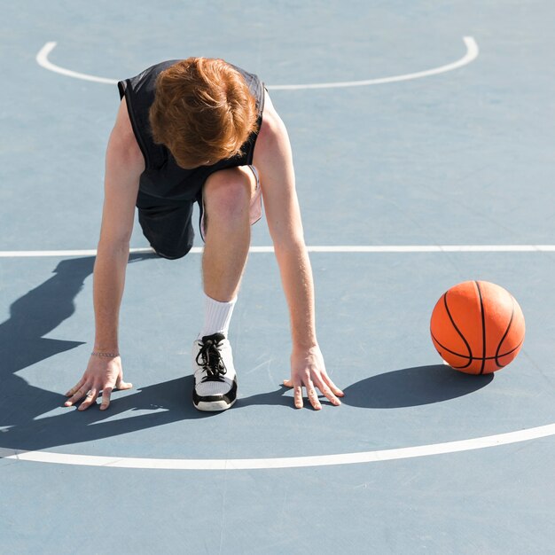 Tiro de menino com bola de basquete