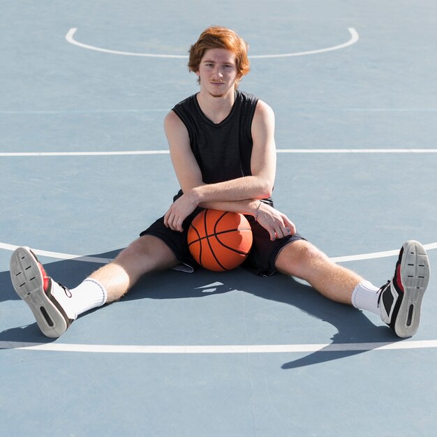 Tiro de menino com bola de basquete