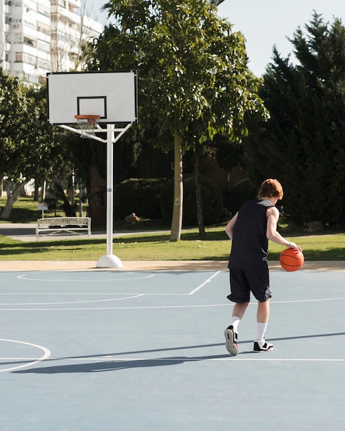 Tiro de menino jogando basquete