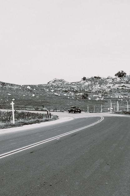 Foto grátis tiro em escala de cinza vertical de uma estrada rural