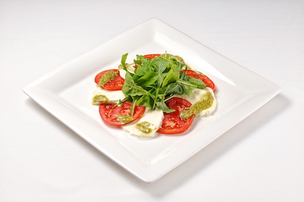 Foto grátis tiro isolado de um prato branco com salada caprese - perfeito para um blog de comida ou menu