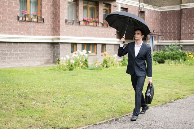 Tiro longo, de, homem negócios, segurando guarda-chuva